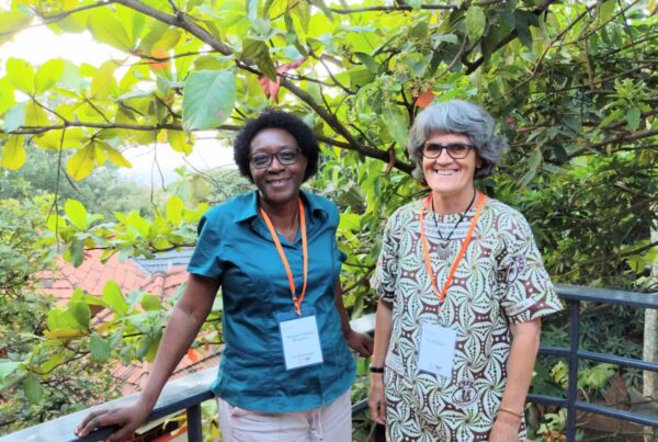 two women pose on a scenic balcony